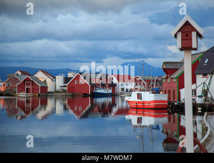 Waterfront Holzhäuser und Fischerboote im Wasser spiegeln im Hafen von Kalvaag - einem kleinen Dorf in Bremanger Norwegen Stockfoto