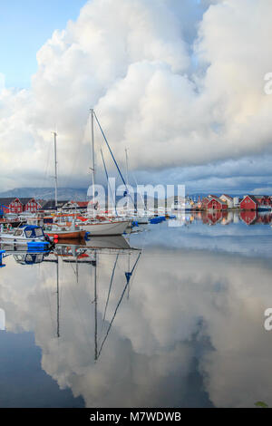 Boote und Wolken spiegeln in das klare Wasser des Kalvaag - einem kleinen Dorf in Bremanger Norwegen Stockfoto