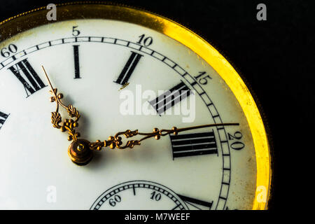 Close-up auf eine alte Uhr mit abgeschnittenen schwarzer Hintergrund Stockfoto