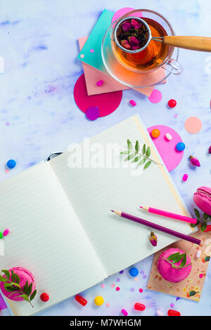 Feminine flach mit Tee, Süßigkeiten und offenes Buch mit leeren Seiten. Bunte party Hintergrund mit Konfetti. Planung Konzept mit kopieren. Stockfoto