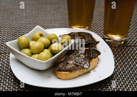 Spanische Tapa-Set mit Oliven und Chorizo, einer pikanten Spanische Wurst aus Schweinefleisch, auf bar Tisch. Stockfoto