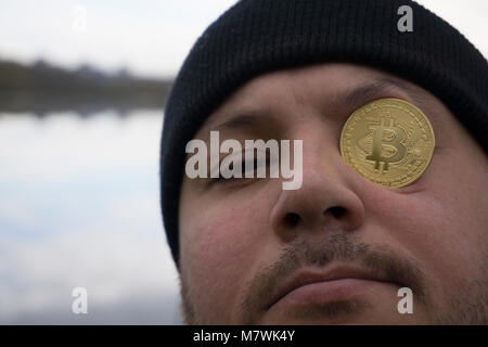 Ein ernster Mann mit bitcoin (Neues virtuelles Geld) Stockfoto