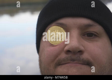 Ein ernster Mann mit bitcoin (Neues virtuelles Geld) Stockfoto