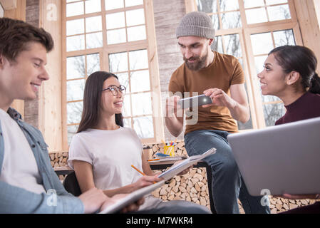 Netter Mann sein Smartphone in den Händen halten, freuen Stockfoto
