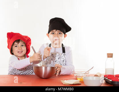 Süße kleine Kleidung Koch junge Cupcakes vorbereiten Stockfoto
