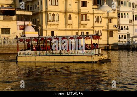 Einen flachen Boden Boot Touristen eine Sunset Cruise auf dem Pichola-see Udaipur Rajashan Indien eingerichtet Stockfoto