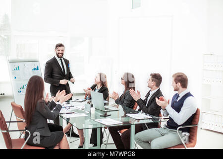 Business Team applaudieren dem Leiter Finanzen bei der Vorstellung des neuen Projektes am Arbeitsplatz Stockfoto