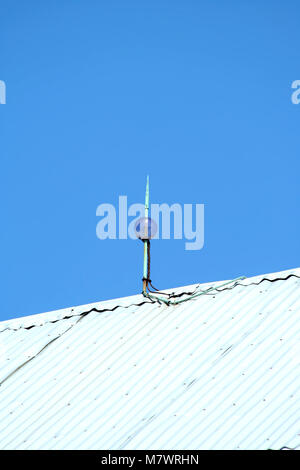 Blitzableiter auf einer Scheune vor blauem Himmel Stockfoto