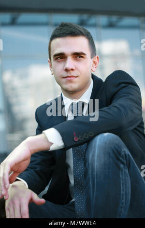 Junge Unternehmer sitzen auf die Schritte des Amtes Stockfoto