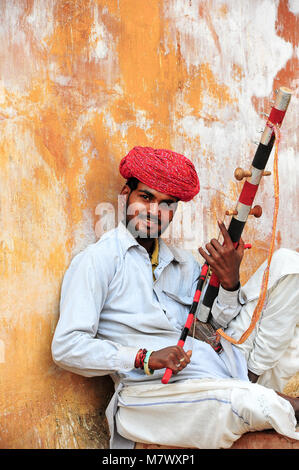 Musiker spielt eine Ravanahatha, einem beliebten Instrument in der Straße Volksmusik in Indien. Porträt eines Mannes, der das Tragen der roten turban Lächeln für die Kamera Stockfoto