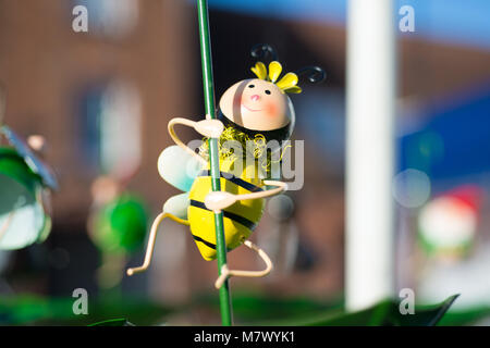 Nettes Spielzeug bumble bee auf pflanzlichen Stammzellen als Garten ornament verwendet Stockfoto