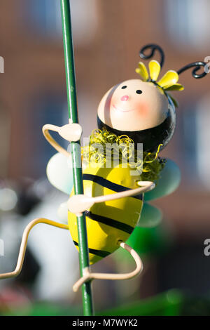 Nettes Spielzeug bumble bee auf pflanzlichen Stammzellen als Garten ornament verwendet Stockfoto