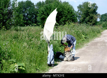 Alte Maler mit Pinsel in der Hand Farben auf Leinwand in der Natur. Stockfoto