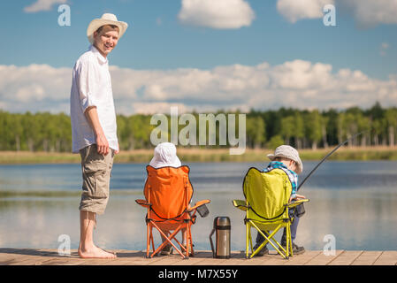 Mann und zwei Söhne auf Angeln, Vater lehrt Kinder, Fisch Stockfoto