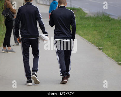 Zwei der gleiche Kerl zu Fuß auf dem Gehweg Stockfoto