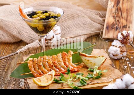 Kalte Vorspeise mit Garnelen mit dem Original Portion Oliven im Glas. Rustikale noch leben. Stockfoto