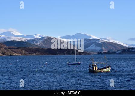 Suchen von Ullapool, Schottland, Loch Broom die Fannich Berge im Winter, mit zwei Fischerboote auf dem Loch. Stockfoto