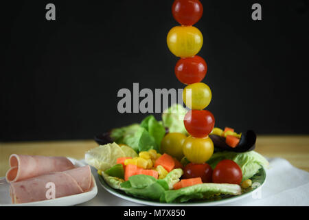 Kreative frische grüne Blattsalat mit Schinken Salat Tomaten und Karotten Stockfoto