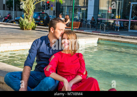 Romantisches Paar auf der Bank sitzen in der Nähe der Stadt Brunnen und genießen Sie Momente des Glücks. Liebe, Dating, Romantik. Lifestyle und Tourismus Konzepte. Stockfoto