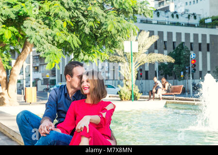 Romantisches Paar auf der Bank sitzen in der Nähe der Stadt Brunnen und genießen Sie Momente des Glücks. Liebe, Dating, Romantik. Lifestyle und Tourismus Konzepte. Stockfoto