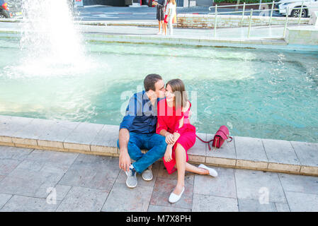 Romantisches Paar auf der Bank sitzen in der Nähe der Stadt Brunnen und genießen Sie Momente des Glücks. Liebe, Dating, Romantik. Lifestyle und Tourismus Konzepte. Stockfoto