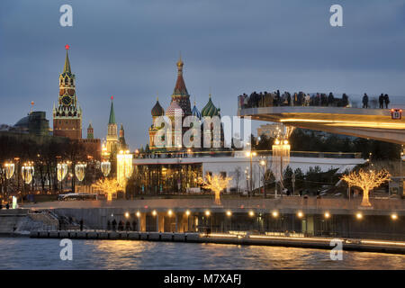 = Sehenswürdigkeiten Moskaus umrahmt von Lichter von zaryadye Park in der Dämmerung= Blick vom Damm des Raushskaya Moskva-Reka (Moskwa) auf Menschen zu Fuß auf Stockfoto