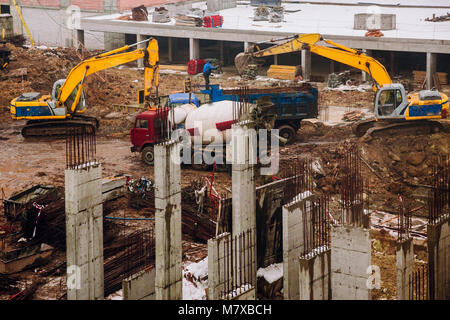 Kranausleger Maschinen und Bulldozer auf den Aufbau Baustelle auf dem Hintergrund der schmutzigen Boden. Industrielle Landschaft mit Kränen und Gebäude, und wor Stockfoto