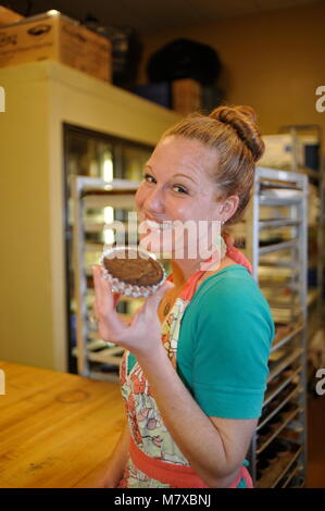 Frau Bäcker bei Ihrer kleinen gewerblichen Bäckerei Küche in den USA arbeiten. Stockfoto