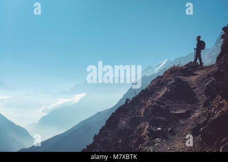 Stehende Frau auf dem Hügel gegen Berg Tal bei hellen, sonnigen Tag. Landschaft mit Mädchen, Pfad, Berge, blauer Himmel mit Wolken bei Sonnenuntergang in Ne Stockfoto