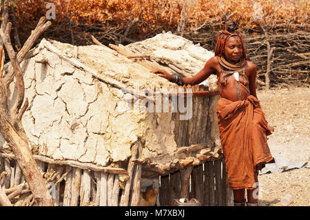 Frau Himba in seinem Dorf in der Nähe von Epupa Falls. Himbas sind normalerweise gefunden in der Nähe der Wasserfälle, wo Sie etwas Geld für Touristen posieren verdienen können, Namibia Stockfoto