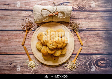 Frisch gebackenen Scones auf einer Holzplatte mit verschiedenen Gewürzen auf Holzlöffel, Ansicht von oben Stockfoto