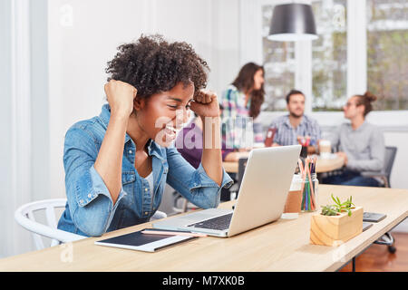 Junge start-up Frau Prost mit geballten Fäusten in Coworking Büro Stockfoto