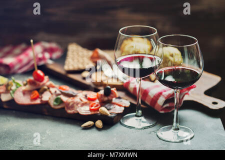 Kalt geräucherte Fleisch Platte mit Schinken, Salami und Rotwein in Weingläser für zwei serviert. Stockfoto