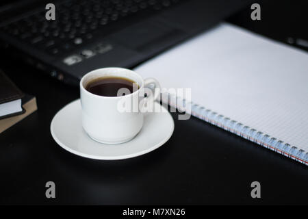 Arbeiten bei einer Tasse Kaffee für Geschäftsleute auf schwarz Tabelle Stockfoto