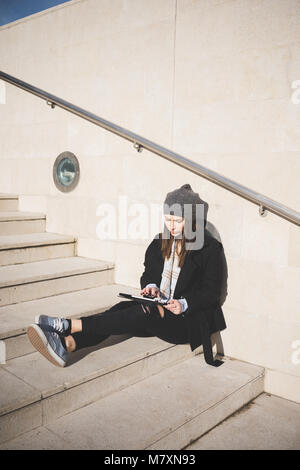 Junge Frau Outdoor Sitzen mit Tablet-Technologie, Small Business, Internet Konzept Stockfoto