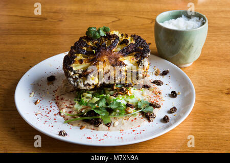 Gegrillten Blumenkohl korma, Koriander und knusprigen Rosinen und gekochtem Reis. Stockfoto