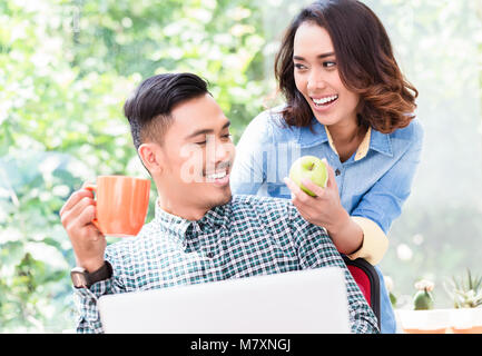 Junge Mitarbeiter auf seine Kollegen in ein entspanntes Arbeiten Stockfoto