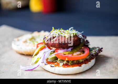 Quinoa Burger, vegan Street Food mit Tomaten und sprießenden Kräutern. Stockfoto