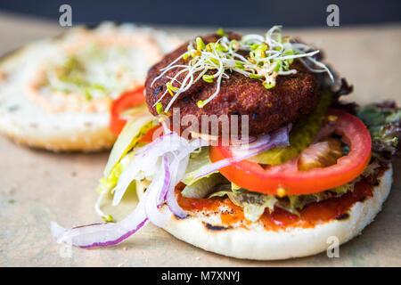 Quinoa Burger, vegan Street Food mit Tomaten und sprießenden Kräutern. Stockfoto