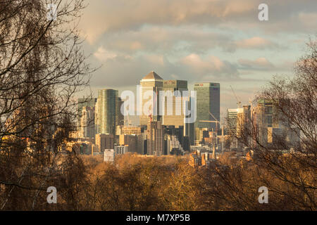 LONDON, GROSSBRITANNIEN - JAN 2018: Moderne Türme von Canary Wharf von Greenwich Park während Sonnenuntergang gesehen Stockfoto