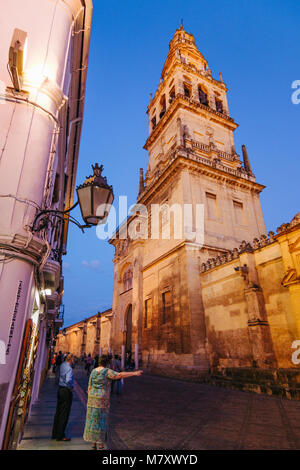 Moschee - Kathedrale von Córdoba. Menschen laufen unter dem Glockenturm leuchtet in der Dämmerung. Cordoba, Andalusien, Spanien. Stockfoto