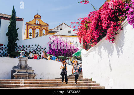 Cordoba, Andalusien, Spanien: Zwei Frauen gehen vorbei Bougainvillea Blumen im Treppenhaus der Cuesta del Bailio Straße mit der Iglesia de los Dolores Stockfoto