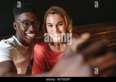 Mann und Frau teilen glückliche Momente im Coffeeshop. Lächelndes Paar ein selfie mit Handy. Stockfoto