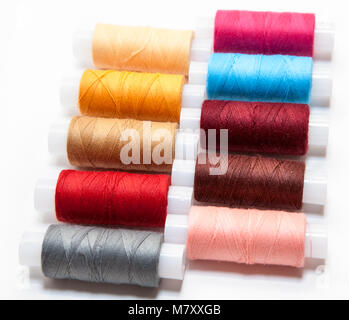In den Zeilen multicolor Sewing Threads auf einem weißen Hintergrund angeordnet Stockfoto