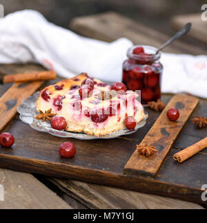 Käsekuchen mit Beeren, Kirschen, die in eine Glasplatte und einen Krug Beeren Stockfoto