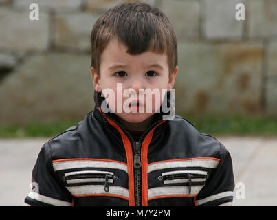 Porträt der kleine Junge mit Motorrad Jacke an Spielplatz gekleidet Stockfoto