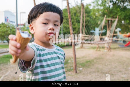 Baby übergeben Eis verdrießlich sein, Fokus Objekt zu Gesicht, Stockfoto