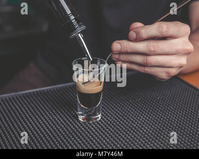 Der Barkeeper bereitet eine B-52 Cocktail an der Bar Stockfoto