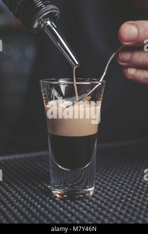 Der Barkeeper bereitet eine B-52 Cocktail an der Bar Stockfoto