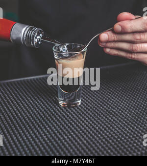 Der Barkeeper bereitet eine B-52 Cocktail an der Bar Stockfoto